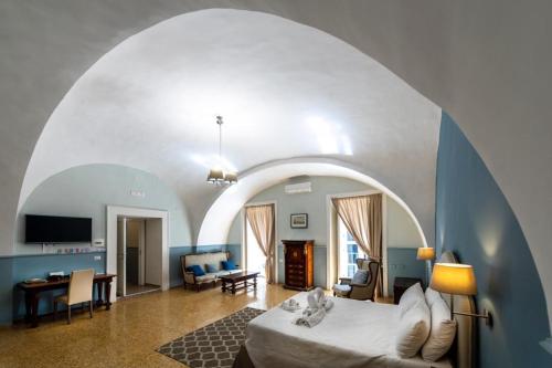 un salon avec un lit et un plafond voûté dans l'établissement Aragonese Luxury Rooms, à Naples