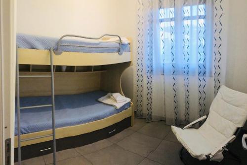カンポフェリーチェ・ディ・ロッチェッラにあるAppartamento Quartiere Biancoの二段ベッド2台と窓が備わる客室です。
