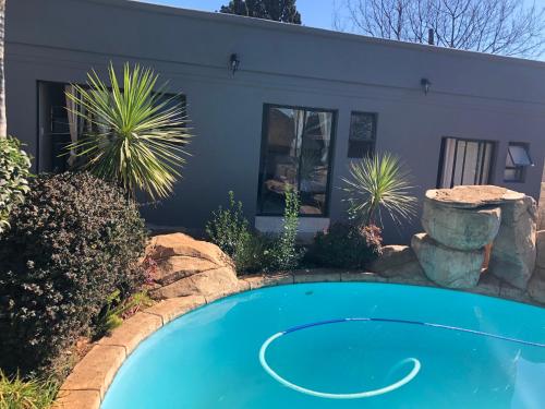 a swimming pool in front of a house at Africaren Budget Stay in Kempton Park