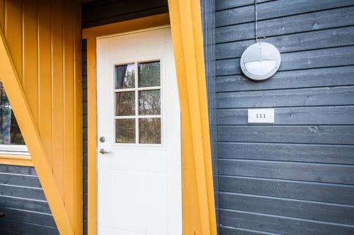 a blue house with a white door and a window at Dolmsundet Hotell Hitra in Melandsjøen