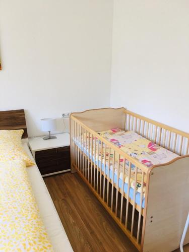 a crib in a bedroom with a bed at Haus Jenni im Schwarzwald, 3,5-Zimmer, große Terrasse in Freudenstadt