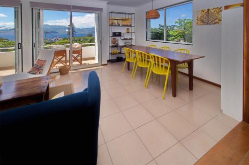 a living room with a dining room table and yellow chairs at epicenter PICO in Madalena