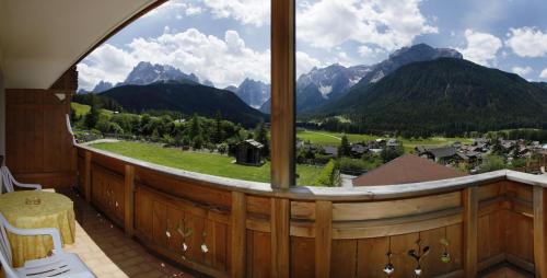 セストにあるApartments Sunseit'nの山の景色を望む大きな窓が付いた客室です。