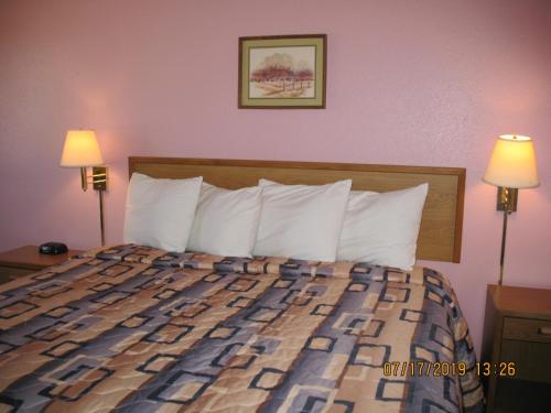 a bed in a hotel room with two lamps at Executive Inn in McPherson