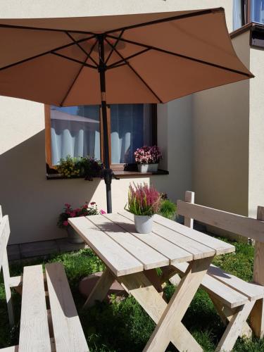 a picnic table with an umbrella and a bench at Sielskie Apartamenty in Sandomierz