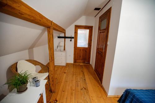 a hallway in a attic with a wooden floor and a door at Chata Pod Lasem in Poręba