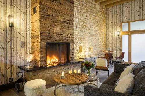 a living room with a fireplace and a couch at Côté Rivière in Nevy-sur-Seille
