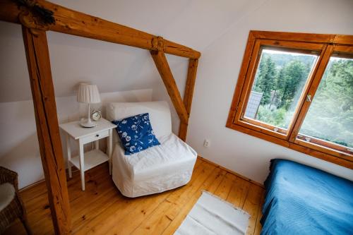 a room with a bed and a table and a window at Chata Pod Lasem in Poręba