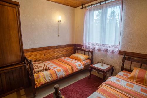 a bedroom with two beds and a window at Lara Rooms in Žabljak