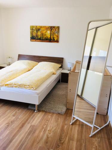 a bedroom with a bed and a mirror at Haus Jenni im Schwarzwald, 3,5-Zimmer, große Terrasse in Freudenstadt