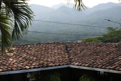 un toit d'une maison avec des montagnes en arrière-plan dans l'établissement Hotel Buena Vista, à Copan Ruinas