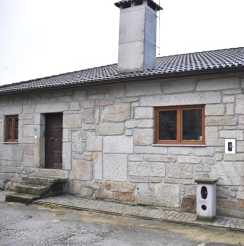 a stone house with a chimney on top of it at Casa do Tavares in Carvalhais