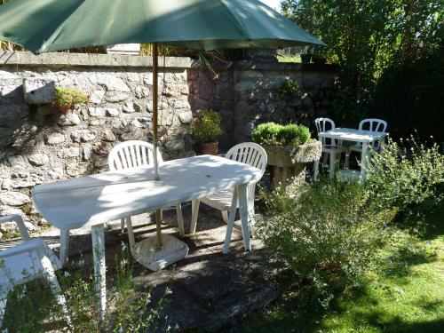 a table and chairs and an umbrella in a yard at Maison Baxter in Prats-de-Mollo-la-Preste