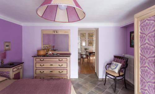 a bedroom with purple walls and a dresser and a mirror at Cadelcivich - Monforte d'Alba in Monforte dʼAlba