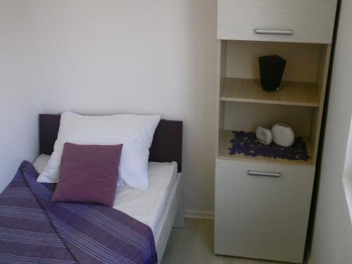 a small bedroom with a bed and a book shelf at Sava in Soko Banja