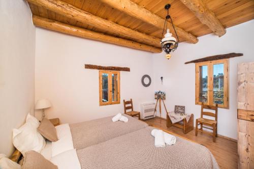 a bedroom with a large bed and wooden ceilings at ARADENA TRADITIONAL House 1 in Arádhaina