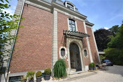 a red brick building with a door and plants at Villa de Noailles in Spa