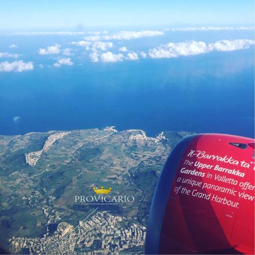 a view of the wing of an airplane flying over the ocean at Provicario in Victoria