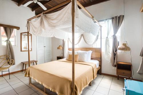 a bedroom with a canopy bed in a room at Selina Manuel Antonio in Manuel Antonio