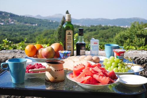 una mesa con platos de fruta y botellas de vino en Rustic Stone House en Bar