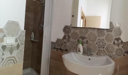 a bathroom with a sink and a mirror and a shower at Appartamento L'Ammiraglio in Trapani