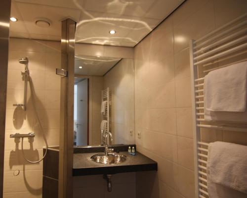 a bathroom with a sink and a mirror at De Wapser Herberg in Wapse