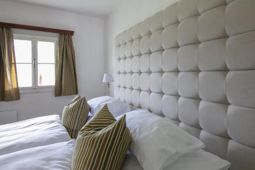 a large white bedroom with a large padded headboard at Haus Annerl in Stainz