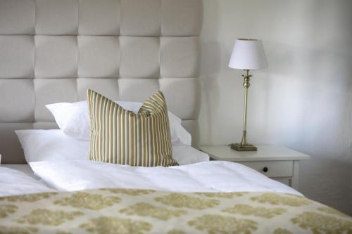 a bed with a yellow and white pillow and a lamp at Haus Annerl in Stainz
