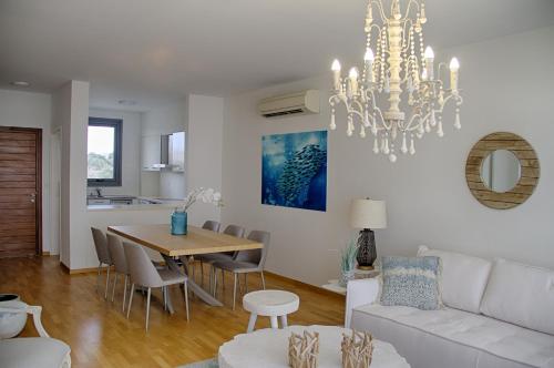 a living room with a white couch and a table at Atlantis Gardens in Mazotos