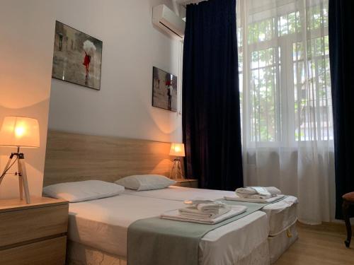 1 Schlafzimmer mit 2 Betten und einem großen Fenster in der Unterkunft Piccolo Casa Bella Hotel in Tbilisi City