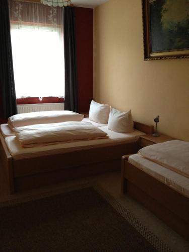 two beds in a room with a window at Hotel Gasthof Turm in Grünhaid