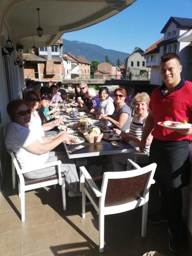 a group of people sitting around a long table at Apartmani Ambiente in Plav