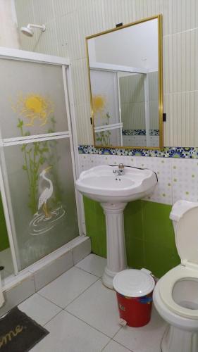 ein Badezimmer mit einem Waschbecken, einem WC und einem Spiegel in der Unterkunft Hostal Nuevo Amanecer in El Coca