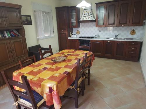 cocina con mesa y sillas y cocina con encimera en Sole Terra e Mare casa Chiara, en Montallegro