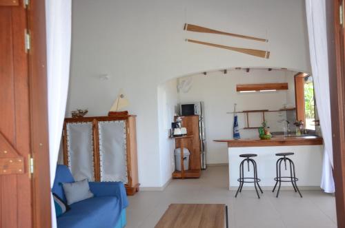 a living room with a blue couch and a kitchen at villa stenella in Bouillante
