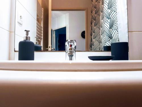 une salle de bain avec un lavabo et un miroir dans l'établissement L'Idylle : T2 de standing avec parking - Gare/Cité des Congrès/Lieu Unique, à Nantes