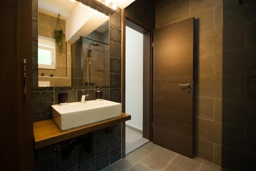 La salle de bains est pourvue d'un lavabo blanc et d'un miroir. dans l'établissement d'House Vinišće, à Vinišće