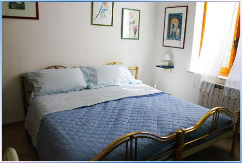 a bedroom with a bed with a blue comforter at Il Giardino Segreto (Villa Cristina) in Lerici
