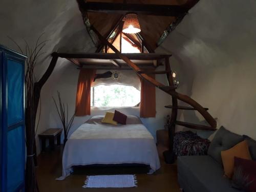 ein Schlafzimmer mit einem Bett und einem Fenster in einem Zimmer in der Unterkunft Recanto das Corujas in Pirenópolis