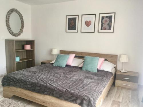 1 dormitorio con 1 cama con almohadas azules y rosas en Rákóczi12 Vendégház, en Hollókő