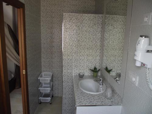 y baño con lavabo y espejo. en Hostal El Canario, en Conil de la Frontera