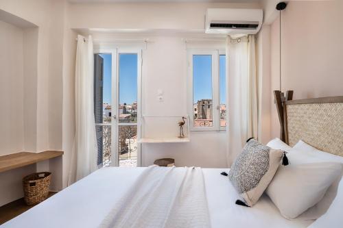 ハニア・タウンにあるArtemide city places-Cozy Roomsのベッドルーム(大きな窓、白いベッド付)