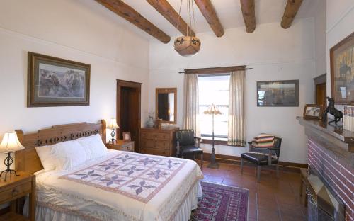 um quarto com uma cama grande e uma lareira em Casa del Gavilan Historic Inn em Cimarron