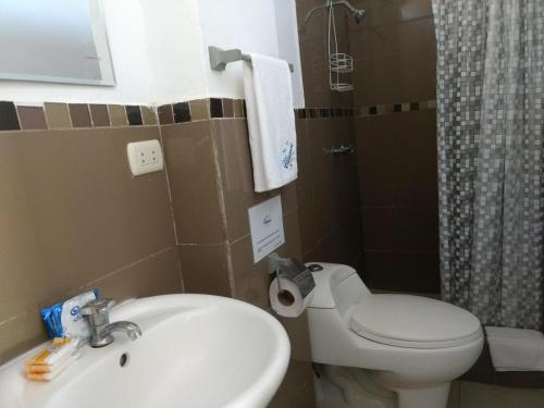 a bathroom with a white toilet and a sink at Casa Villamor in Máncora