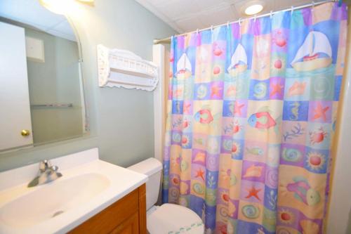 a bathroom with a shower curtain with a toilet and a sink at Breakaway East 109 in Ocean City