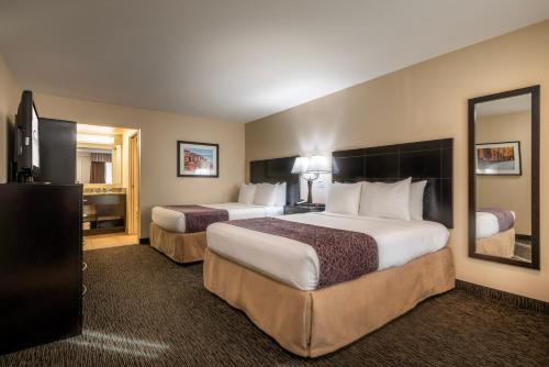 a hotel room with two beds and a mirror at Grand Legacy At The Park in Anaheim