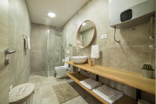 a bathroom with a sink and a toilet and a mirror at Villa Meereen in Klis