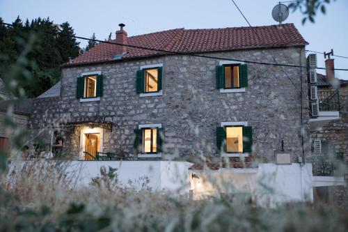 an old stone house with green shutters on it at Villa Meereen in Klis