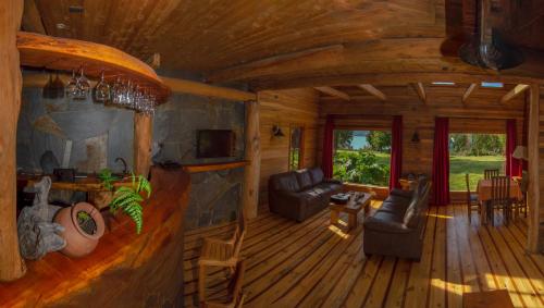 a living room of a log cabin with a couch and chairs at Andes Lodge, Puelo Patagonia in Puelo