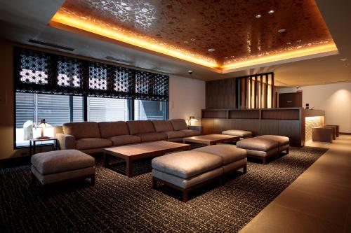 a large living room with a couch and ottoman at S-peria Hotel Kyoto in Kyoto